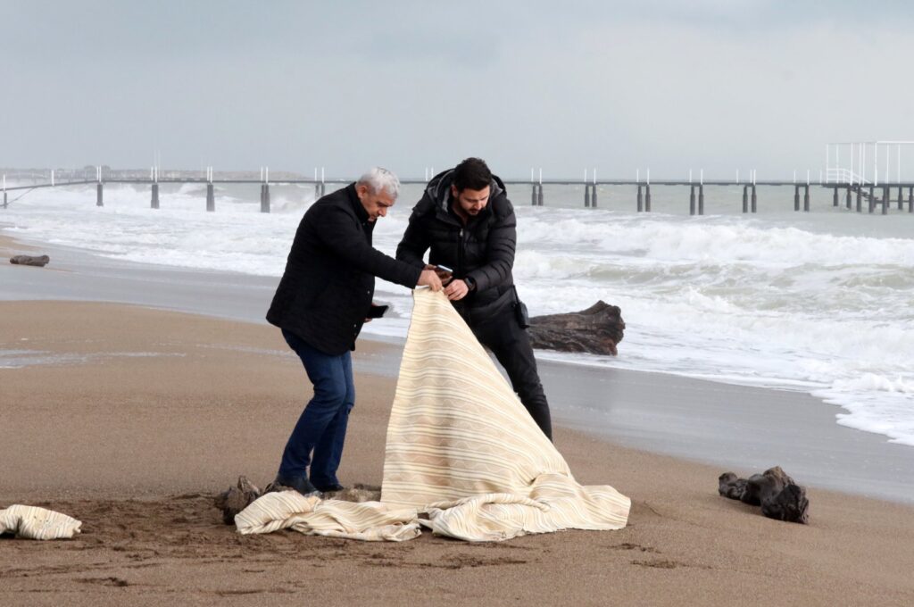 Authorities examine a body that washed ashore on a beach in Antalya, southern Türkiye, Jan. 21, 2024. (DHA Photo)
