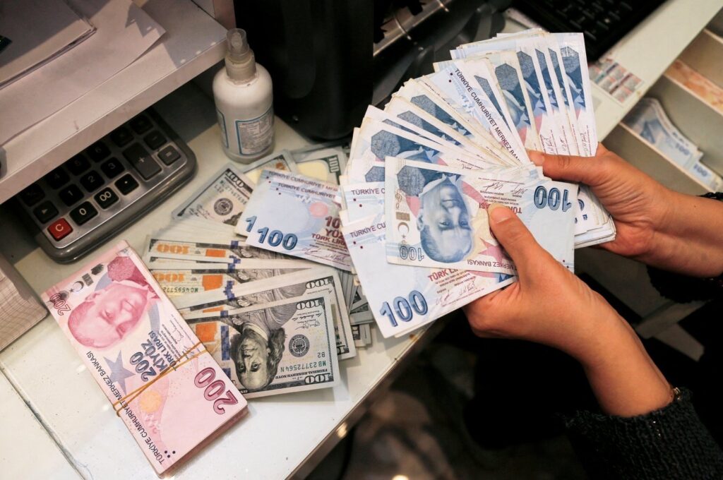 A money changer holds Turkish lira banknotes at a currency exchange office in Ankara, Türkiye, Oct. 12, 2021. (Reuters File Photo)