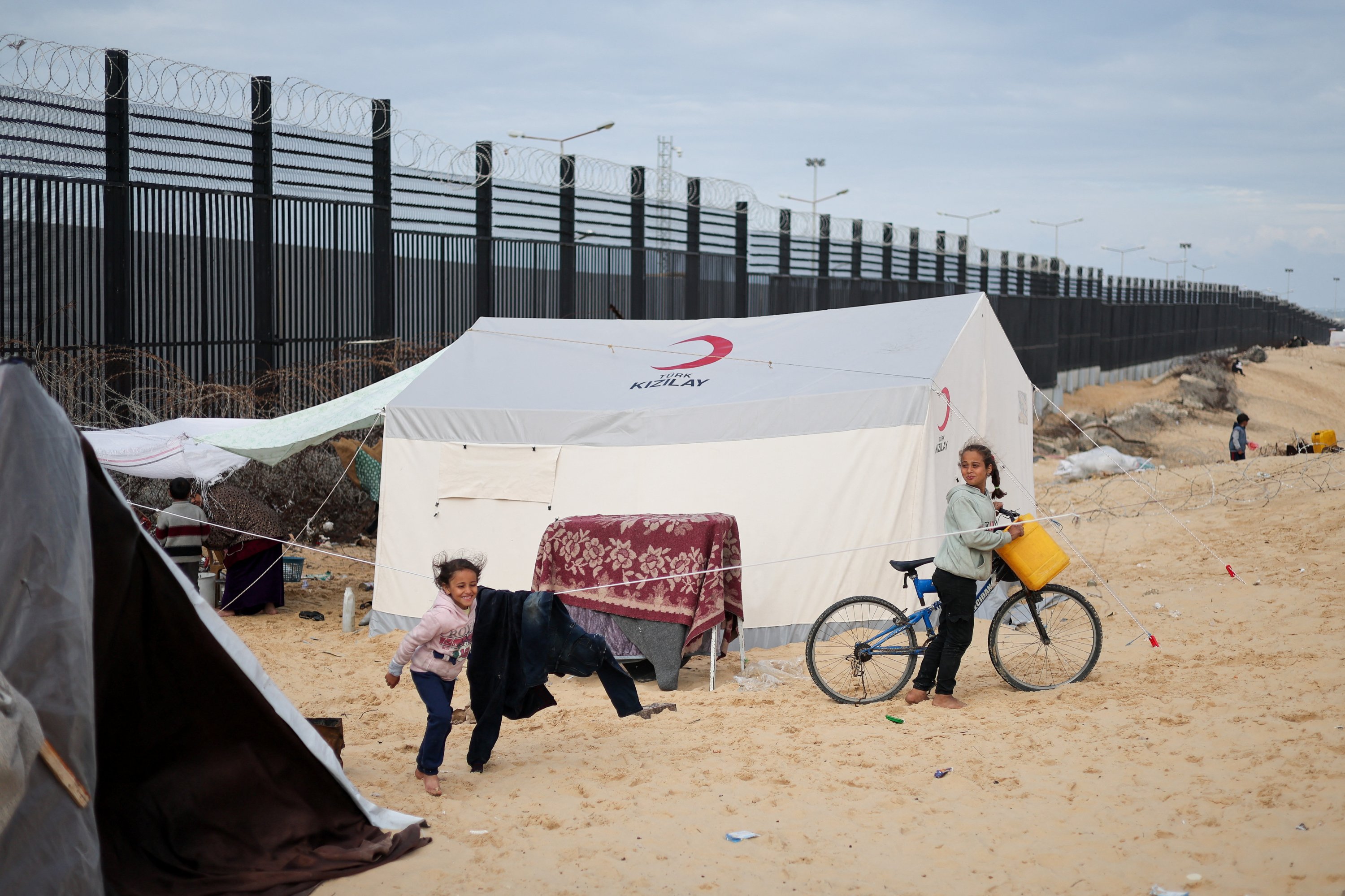 312146 Children stand next to a tent as displaced Palestinians, who fled their houses due to Israeli strikes, shelter at a tent camp, at the border with Egypt, in Rafah in the southern Gaza Strip, Jan. 26, 2024. (Reuters Photo)