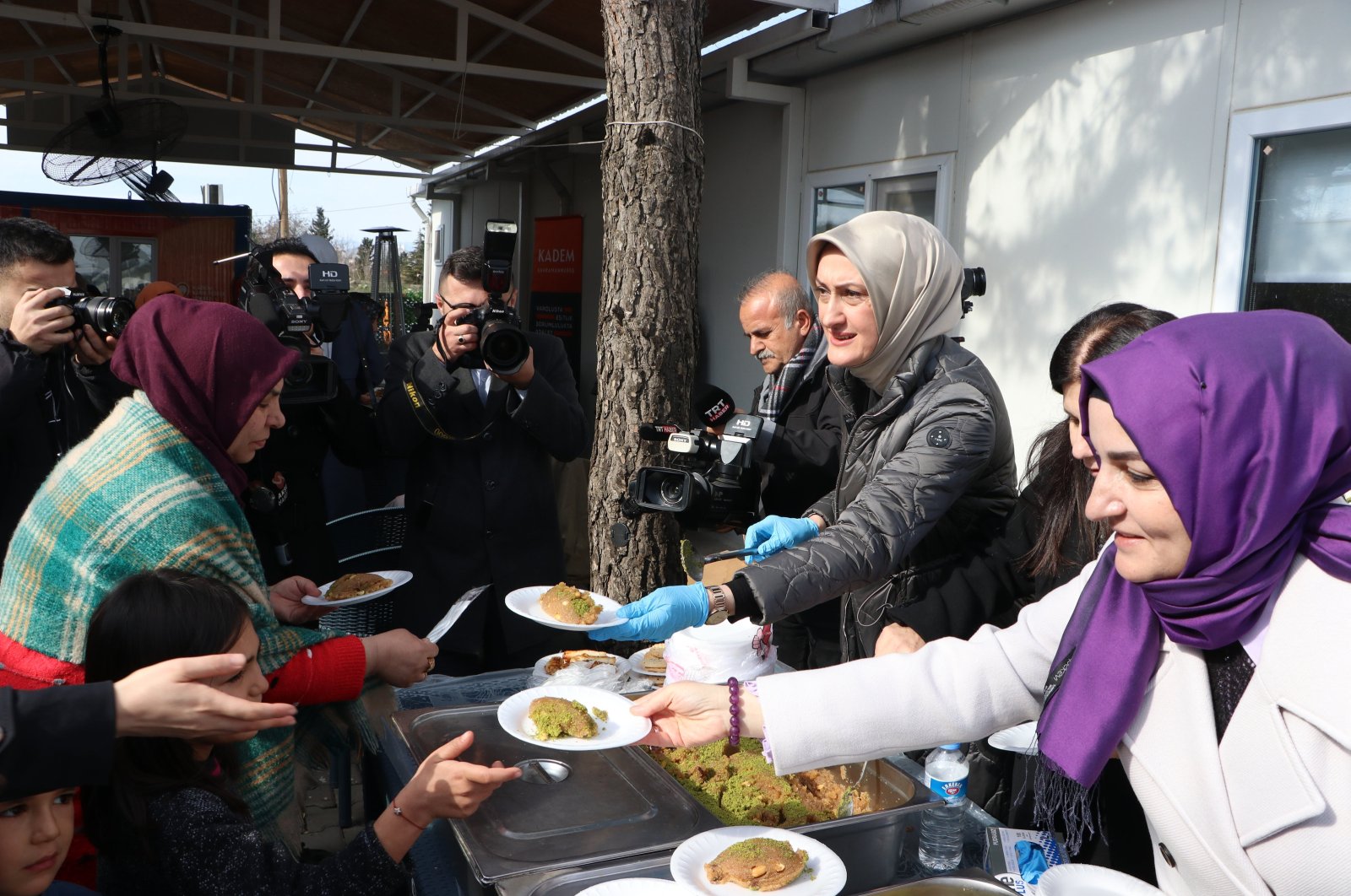Türkiye's Women and Democracy Foundation (KADEM) Chairperson Saliha Okur Gümrükçüoğlu (R) serves a sweet dish for earthquake victims in a container city, Kahramanmaraş, Türkiye, Jan. 30, 2024. (AA Photo)