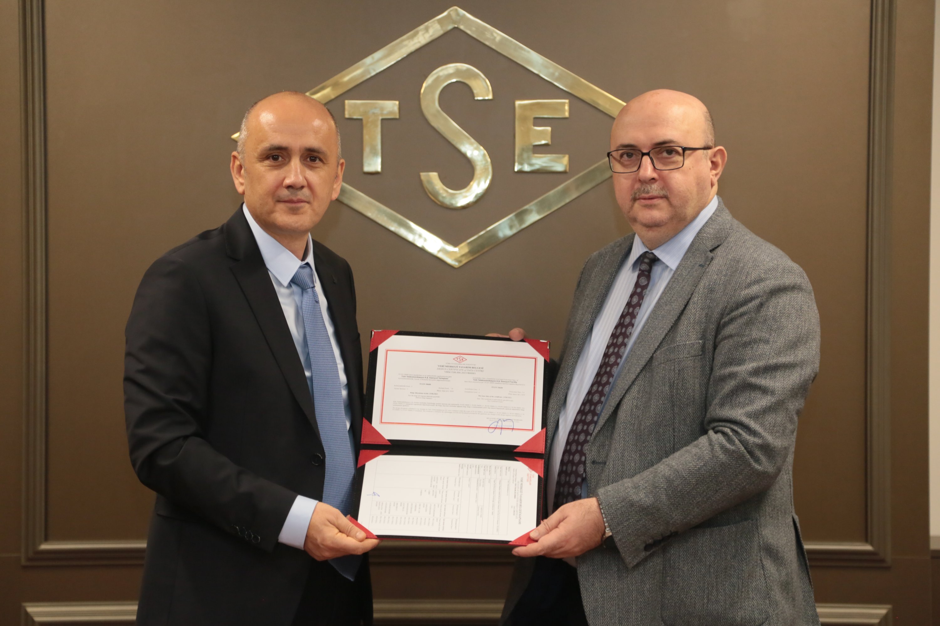 Durmuş Ali Taşkın (R), deputy general manager of Türk Telekom, is handed the TS EN 50600 Design Certificate for the company's Esenyurt Data Center. (Courtesy of Türk Telekom)
