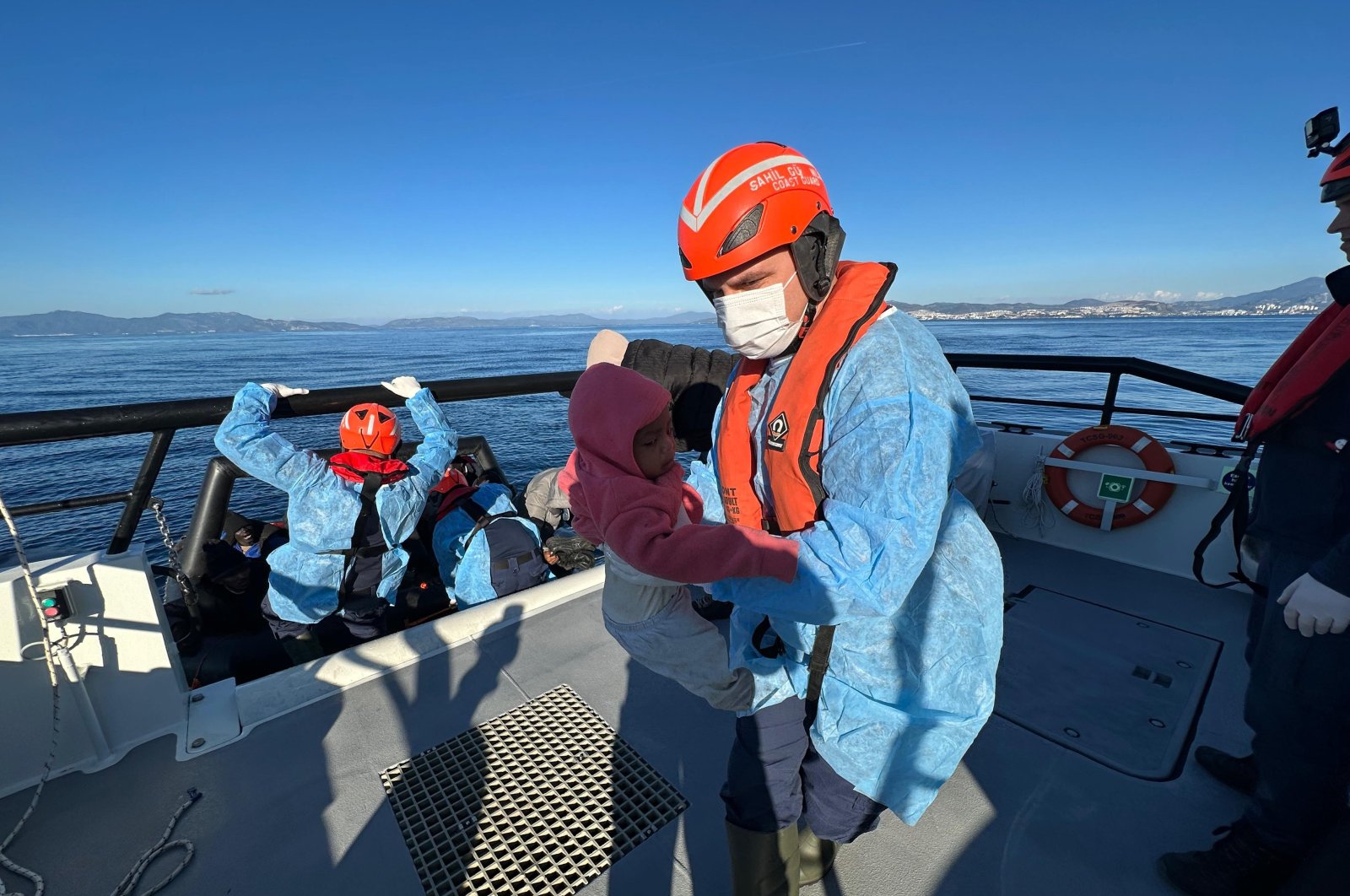 An officer carries an infant as the Turkish coast guard rescues a group of irregular migrants off the coast of western Aydın province, Türkiye, Jan. 31, 2024. (IHA Photo)