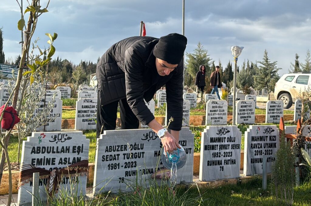 Muhammed Berat visits the graves of his mother, father and two sisters who lost their lives in the Feb. 6 earthquakes, Adıyaman, Türkiye, Feb. 5, 2024. (AA Photo)