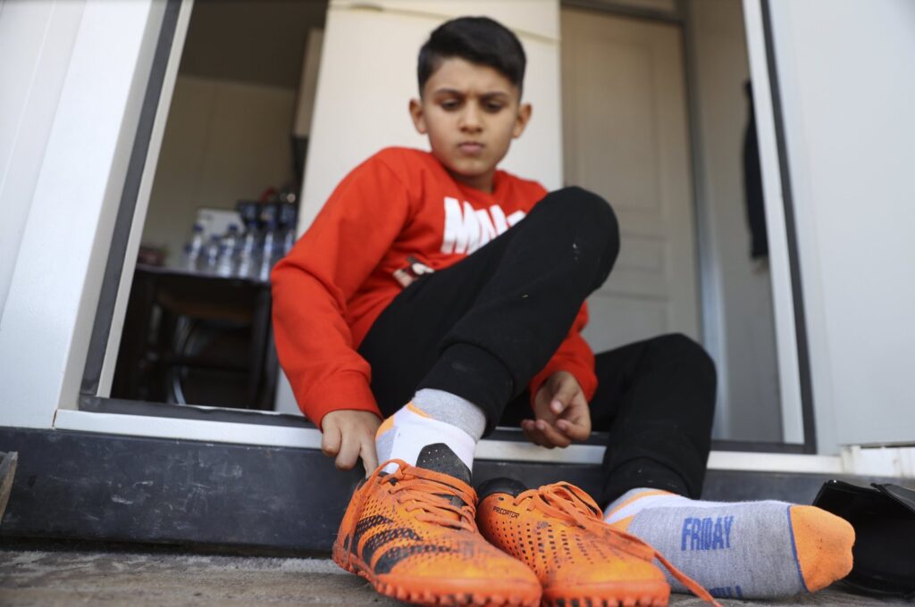 Southeastern Türkiye earthquake survivor Semih Ege Inci puts on his football cleats for training, Gaziantep, Türkiye, Feb. 5, 2024. (AA Photo)
