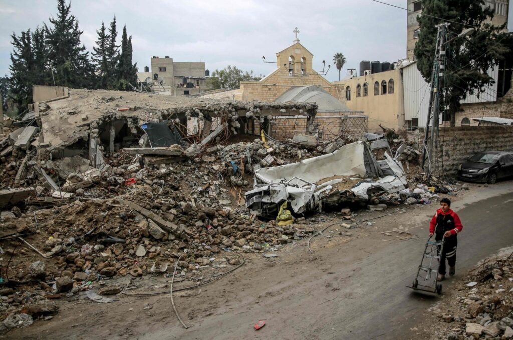 A young boy walks in front of Gaza City's Greek Orthodox Church of Saint Porphyrius, which was damaged in Israeli bombardment on Jan. 5, 2024. (AFP File Photo)
