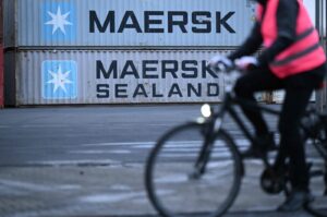 A cyclist drives past containers with the logo of Danish shipping giant Maersk stacked at a transshipment station, Frankfurt, Germany, Jan. 23, 2024. (AFP Photo)