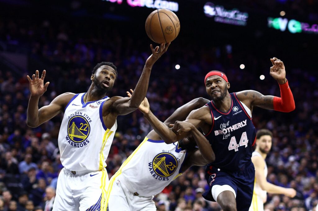 Golden State Warriors Andrew Wiggins (L) reaches for a rebound past Philadelphia 76ers' Paul Reed at the Wells Fargo Center, Philadelphia, Pennsylvania, U.S., Feb. 7, 2024. (AFP Photo)