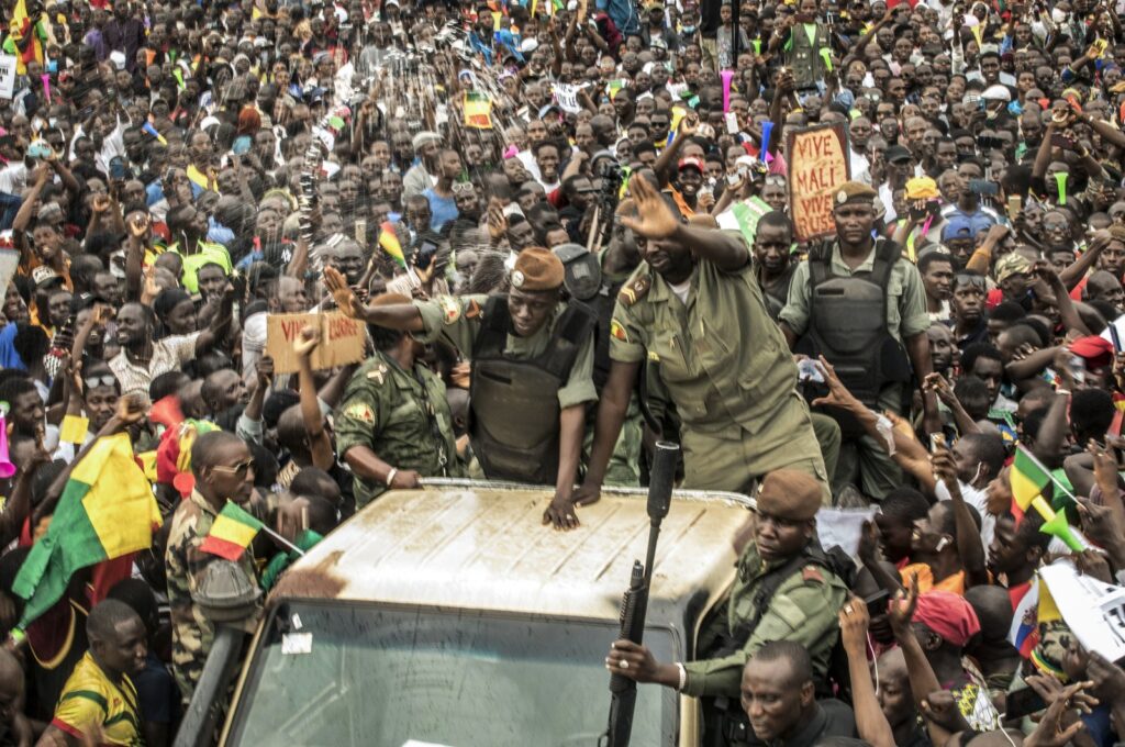 An unidentified representative of the junta waves from a military vehicle as Malians supporting the overthrow of President Ibrahim Boubacar Keita gathers to celebrate in the capital Bamako, Mali, Aug. 21, 2020. (AP File Photo)