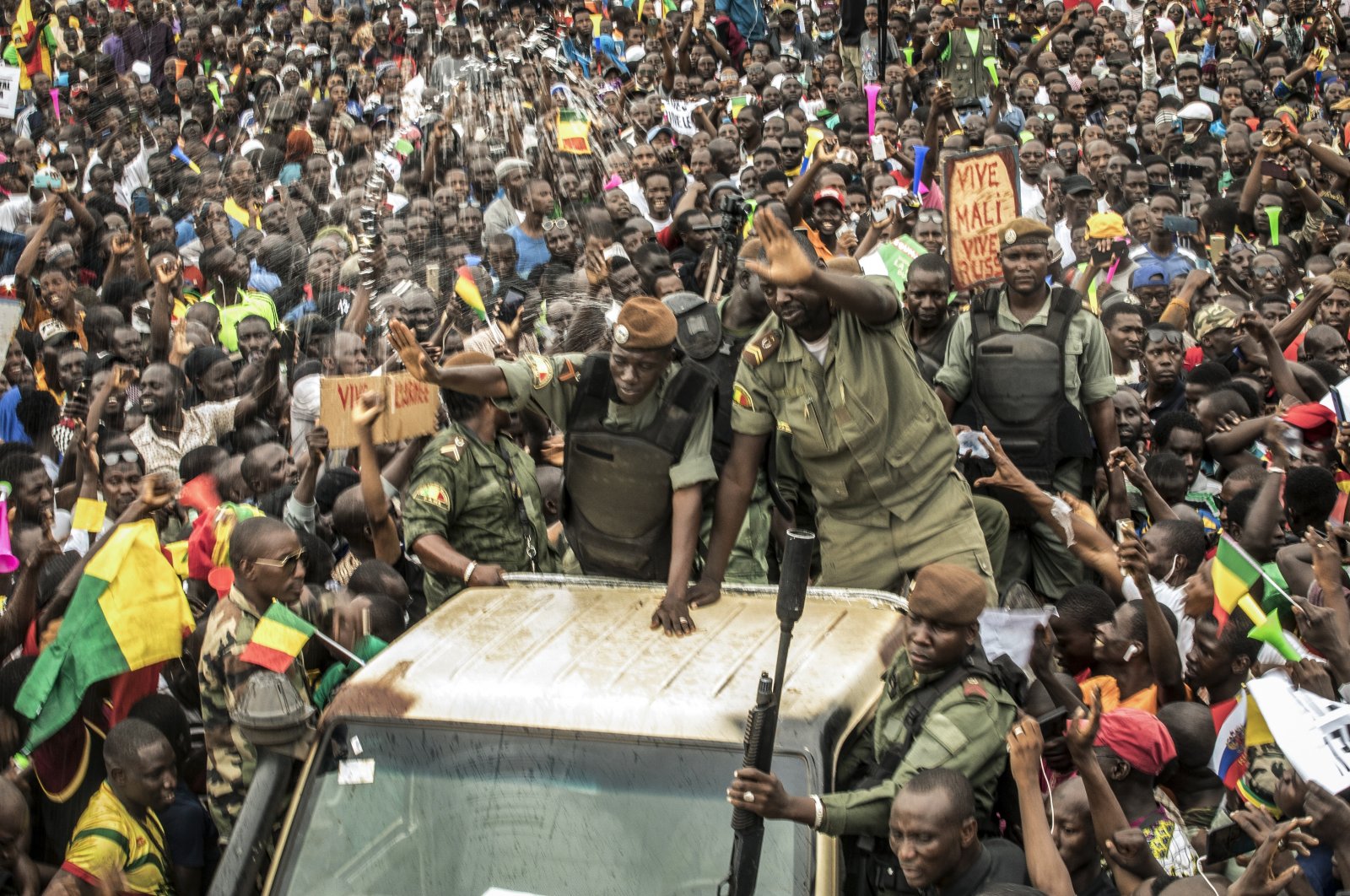 An unidentified representative of the junta waves from a military vehicle as Malians supporting the overthrow of President Ibrahim Boubacar Keita gathers to celebrate in the capital Bamako, Mali, Aug. 21, 2020. (AP File Photo)