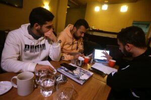 Students study at a cafe in Damascus amid Syria's infrastructure struggles, where power outages last up to 20 hours a day, turning cafes into co-working spaces. (AFP Photo)
