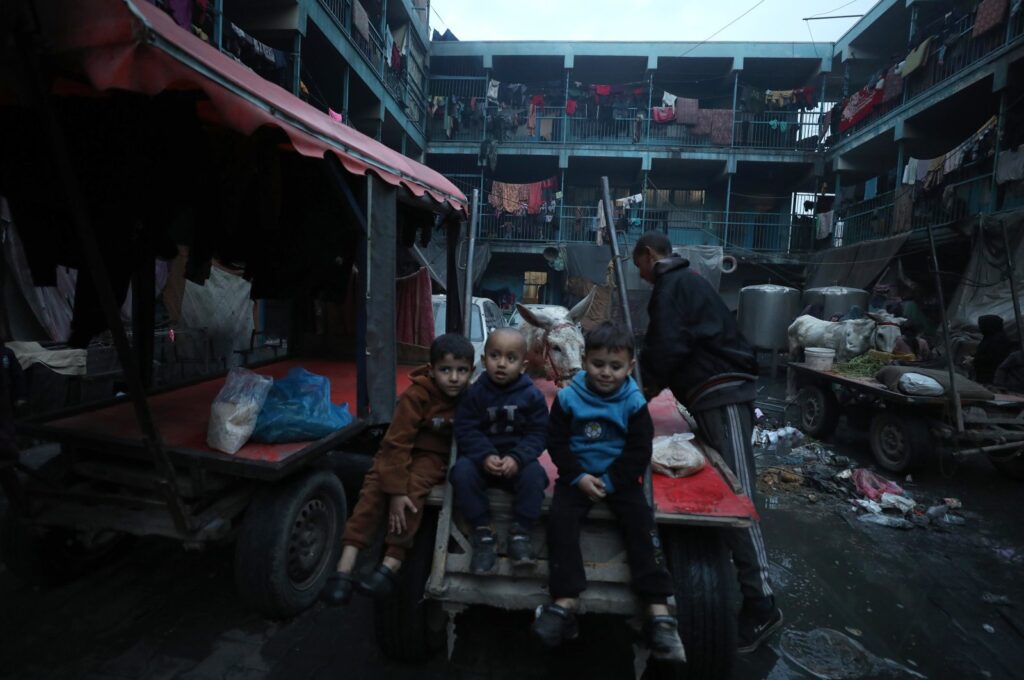 Palestinian children sit at the courtyard of a U.N.-run school and shelter in Gaza, Palestine, Feb. 13, 2024. (AA Photo)