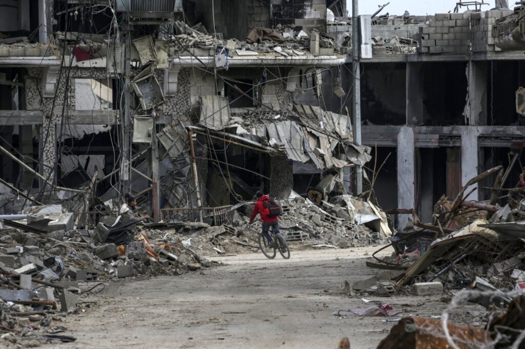 A Palestinian child rides a bike past destroyed houses amid Israeli attacks on Al Bureije refugee camp, southern Gaza Strip, Feb. 13, 2024. (EPA Photo)