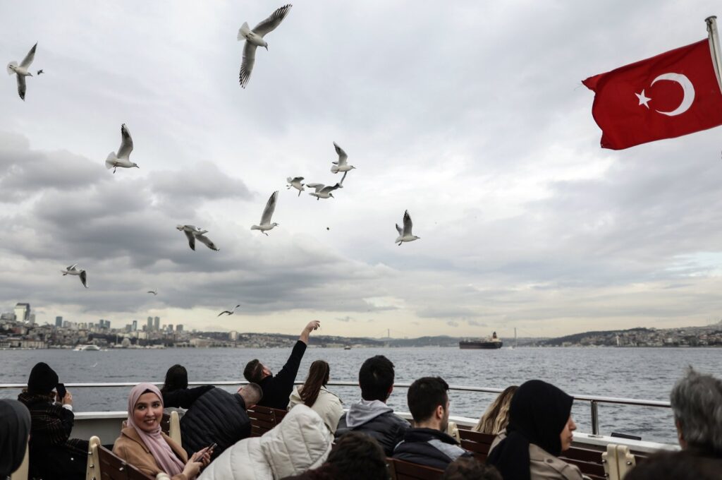 People feed doves as they travel on a ferry during sunset crossing the Bosporus in Istanbul, Türkiye, Feb. 13, 2024. (EPA Photo)