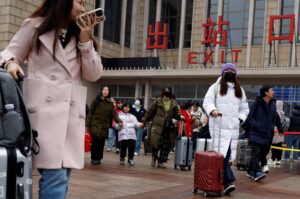 Travelers walk with their luggage outside the Beijing railway station during the Spring Festival travel rush following the 8-day Lunar New Year holiday, Beijing, China, Feb. 18, 2024. (Reuters Photo)