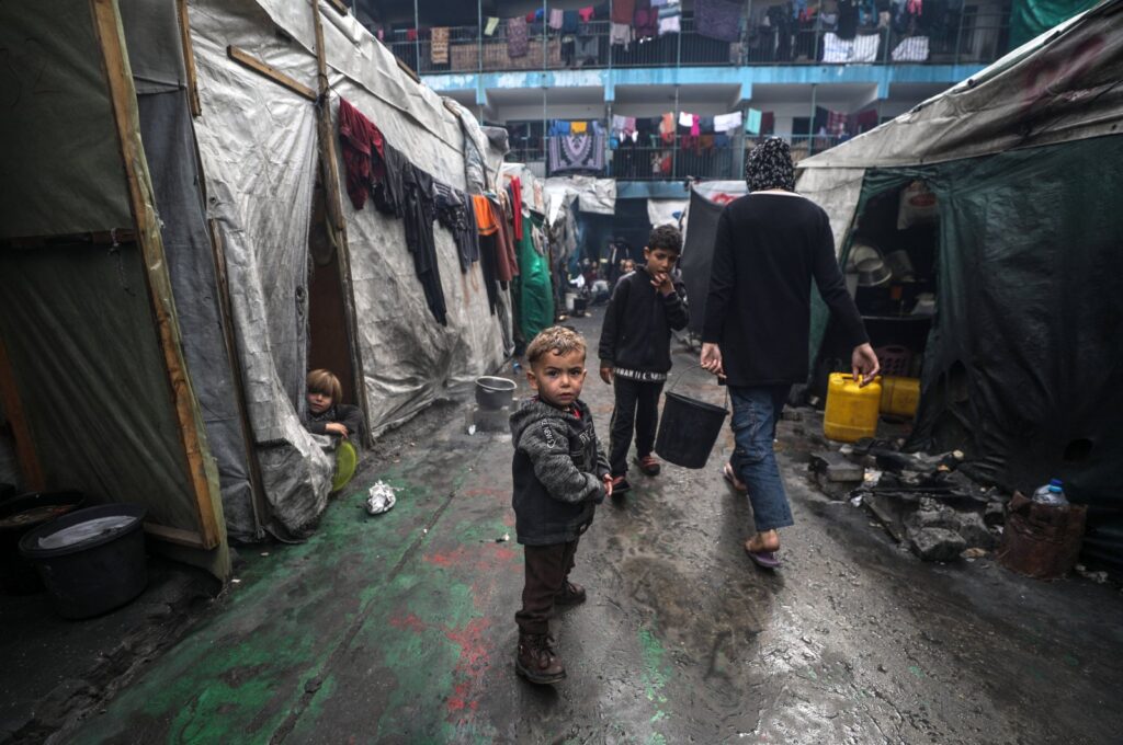 Internally displaced Palestinians walk past their shelters at a United Nations school in Deir Al Balah town, southern Gaza Strip, Feb. 24, 2024. (EPA Photo)