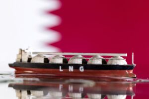 A model of an LNG tanker is seen in front of Qatar's flag in this illustration taken May 19, 2022. (Reuters Photo)