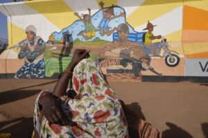 A woman looks at a mural in Ouagadougou, Burkina Faso, March 1, 2023. (AP Photo)