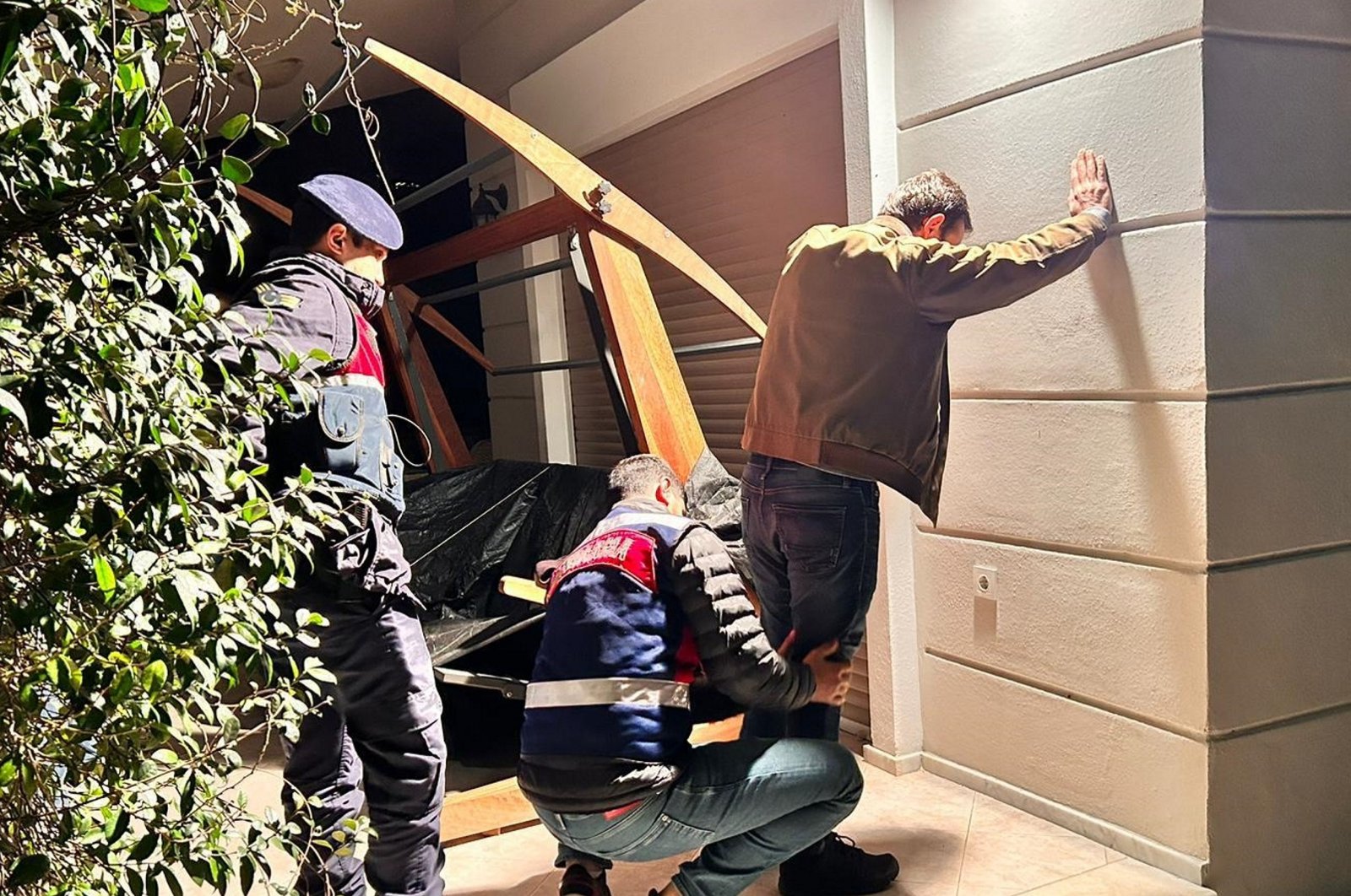 Gendarmerie officers search a suspect accused of financing the DHKP-C and MLKP terror groups during a raid in the western province of Izmir, Türkiye, Feb. 27, 2024. (AA Photo)