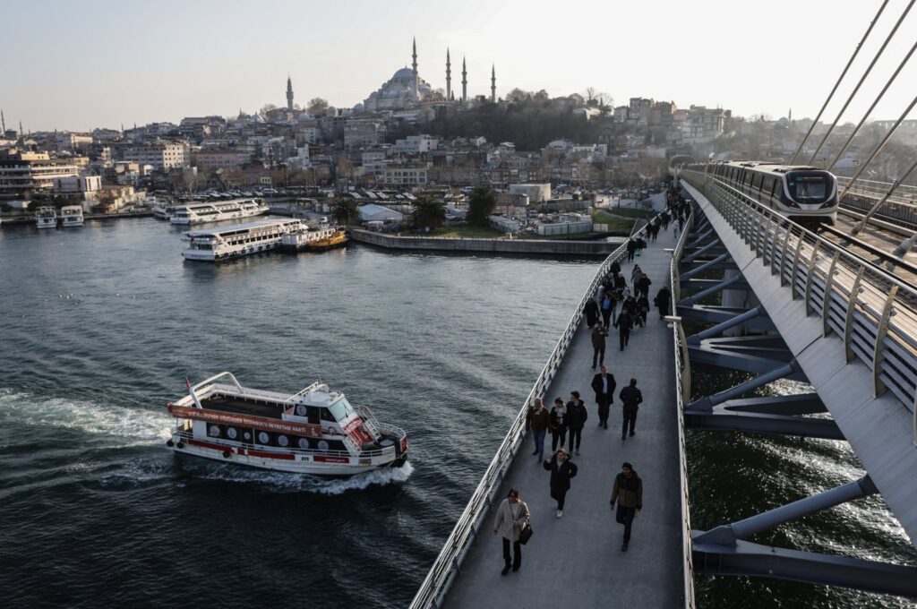 People walk on a bridge backdropped by the Süleymaniye Mosque in Istanbul, Türkiye, Feb. 21, 2024. (EPA Photo)