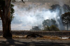 A Caterpillar vehicle sits on a field as a fire burns outside of Beaufort, Victoria, Australia, Feb. 28, 2024. (EPA Photo)