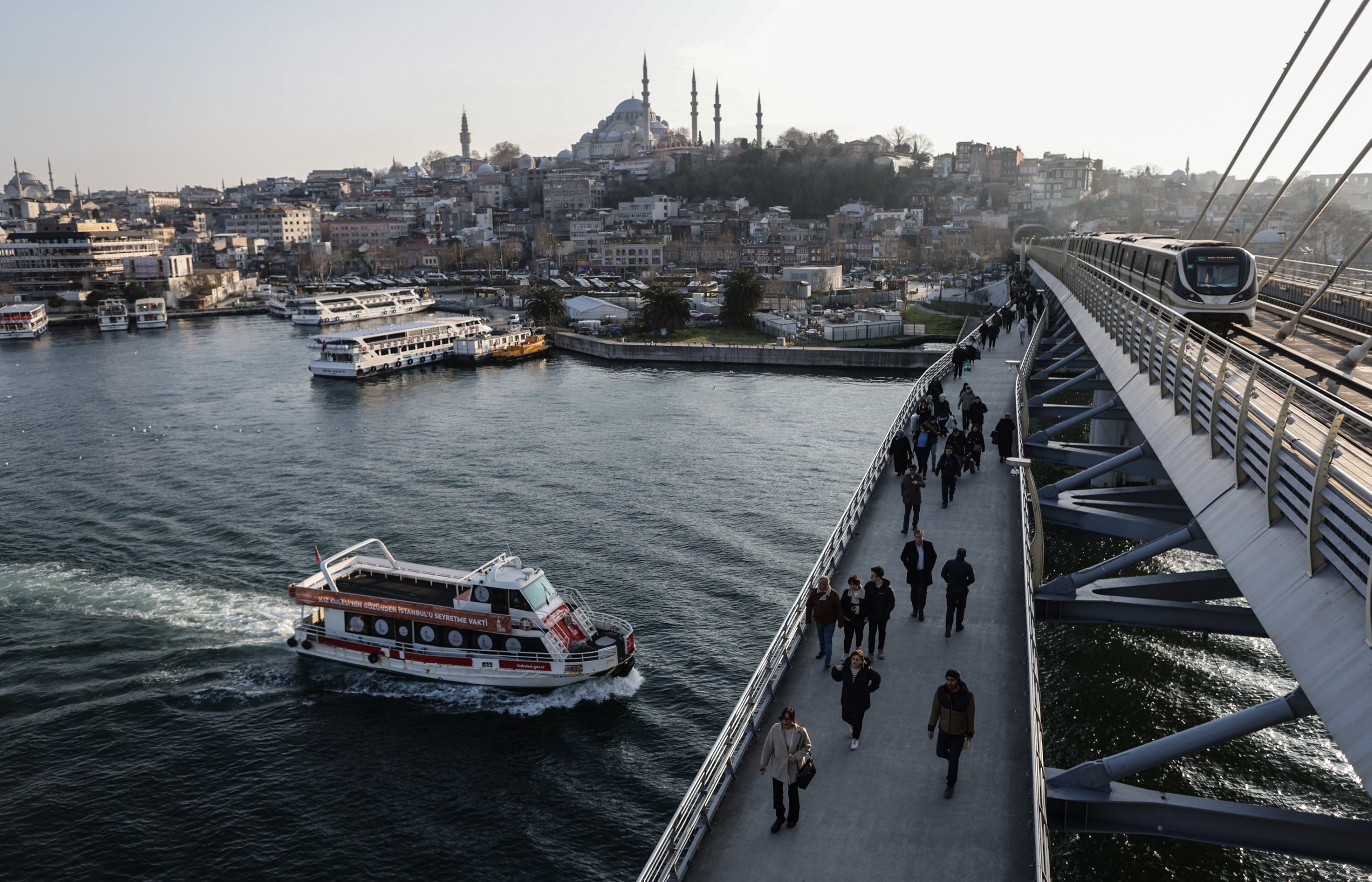 317253 People walk on the bridge backdropped by Süleymaniye Mosque, Istanbul, Türkiye, Feb. 21, 2024. (EPA Photo)