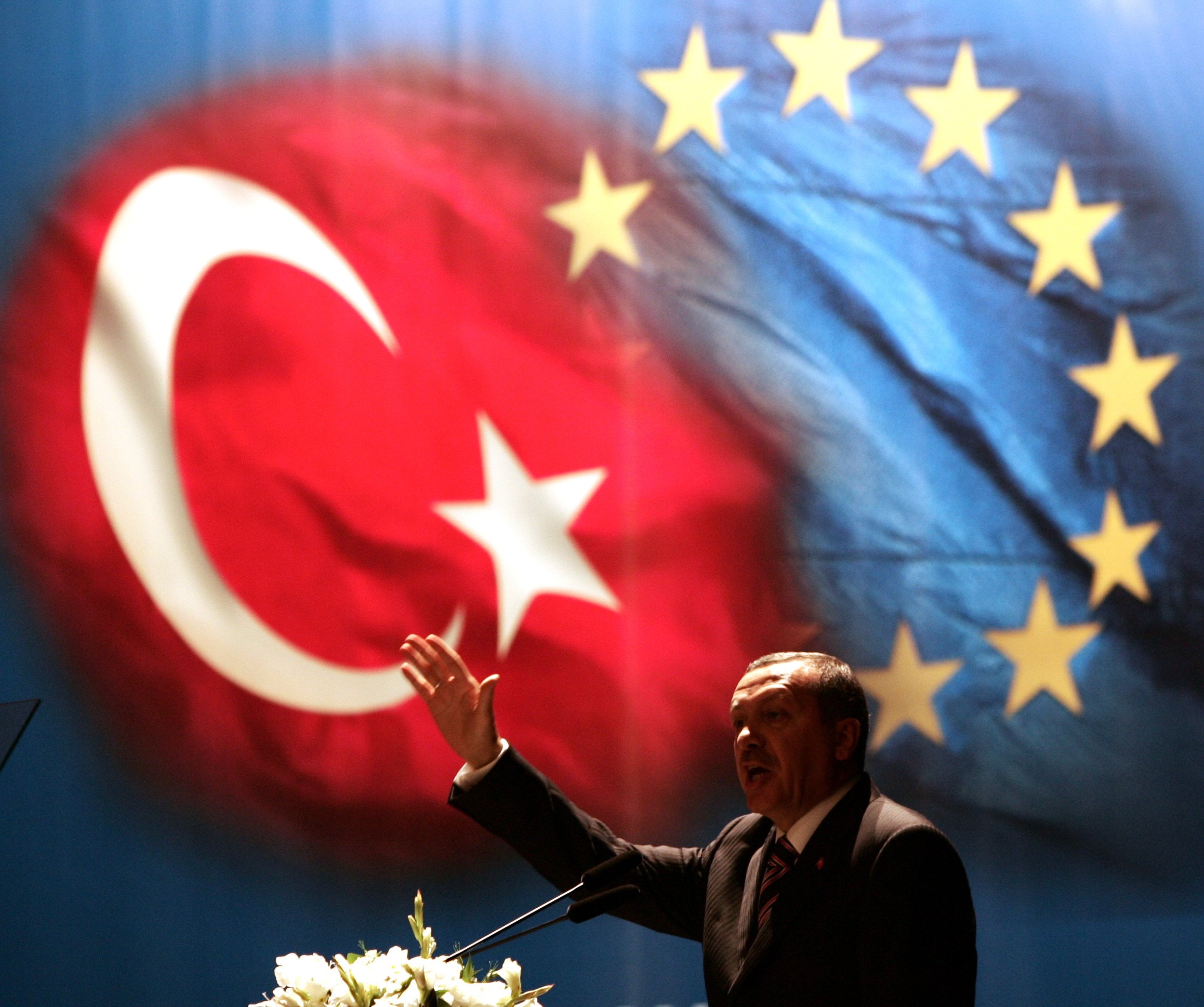 317268 Then-Prime Minister Recep Tayyip Erdoğan gestures under Turkish and EU flags during an iftar dinner that ends the daily fast for Muslims during Ramadan, which then-German Chancellor Gerhard Schroeder also attended, Istanbul, Türkiye, Oct. 12, 2005. (Reuters Photo)