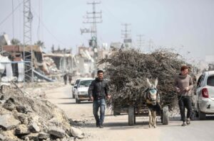 Palestinian men lead a donkey-pulled cart past the ruins of buildings in the Maghazi refugee camp, in central Gaza, Palestine, Feb. 27, 2024. (AFP Photo)