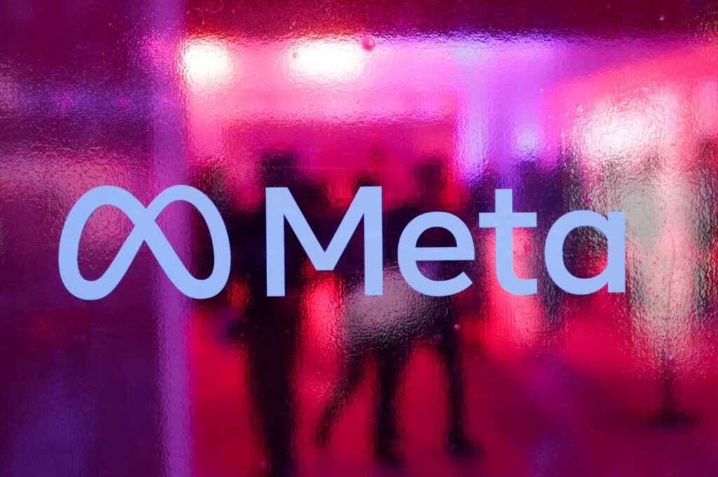 People walk behind a logo of Meta Platforms, during a conference in Mumbai, India, Sept. 20, 2023. (Reuters Photo)