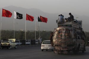People sit on top of a bus as it passes flags of Pakistan and China displayed along a road, ahead of Chinese Premier Li Keqiang's visit to Islamabad, Pakistan, May 21, 2013. (Reuters Photo)