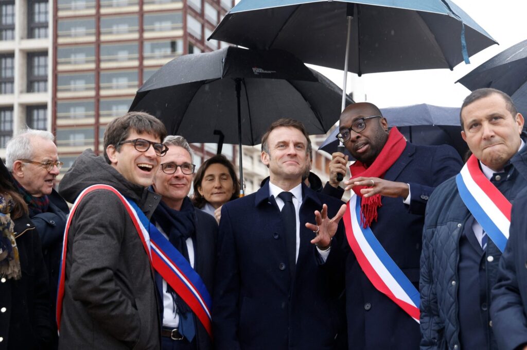 France's President Emmanuel Macron (center), surrounded by officials, during the inauguration of the Paris 2024 Olympic village in Saint-Denis, northern Paris, Feb. 29, 2024. (AFP Photo)