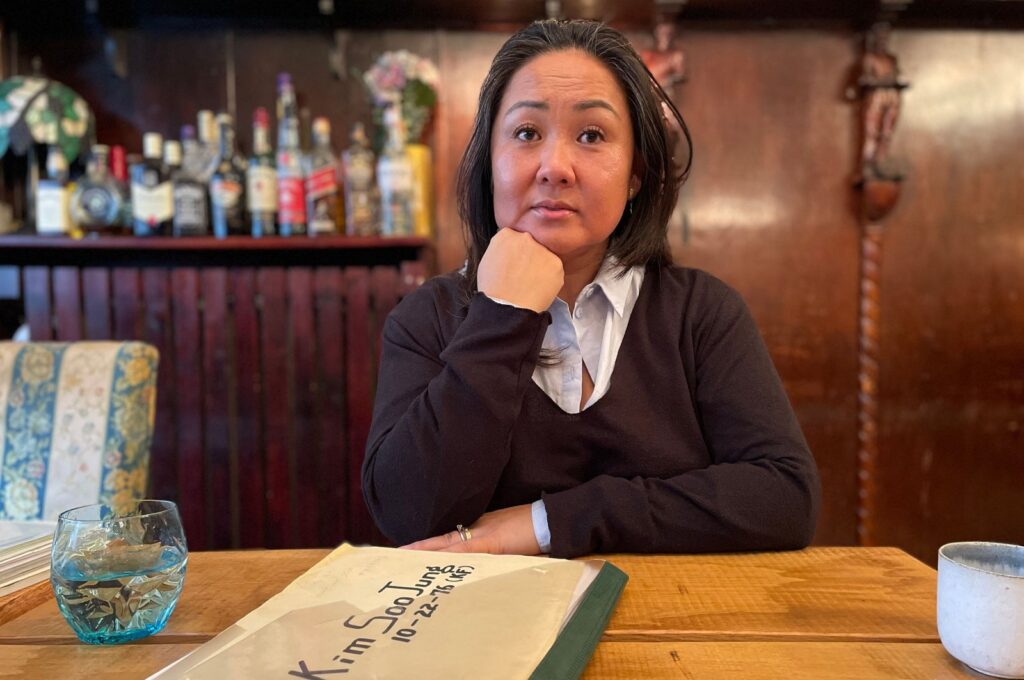 Danish adoptee 47-year old May-Britt Koed poses for a picture as her adoption files are seen on a table, Copenhagen, Denmark, Jan. 30, 2024. (AFP Photo)