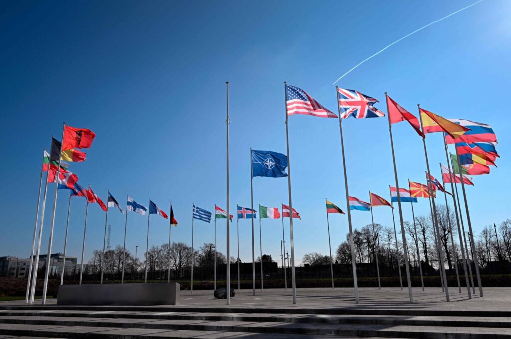 An empty mast amongst member nation flags in the Cour d'Honneur of the NATO headquarters, ahead of a flag-raising ceremony for Sweden’s accession to NATO, in Brussels, Feb. 27, 2024. (AFP Photo)