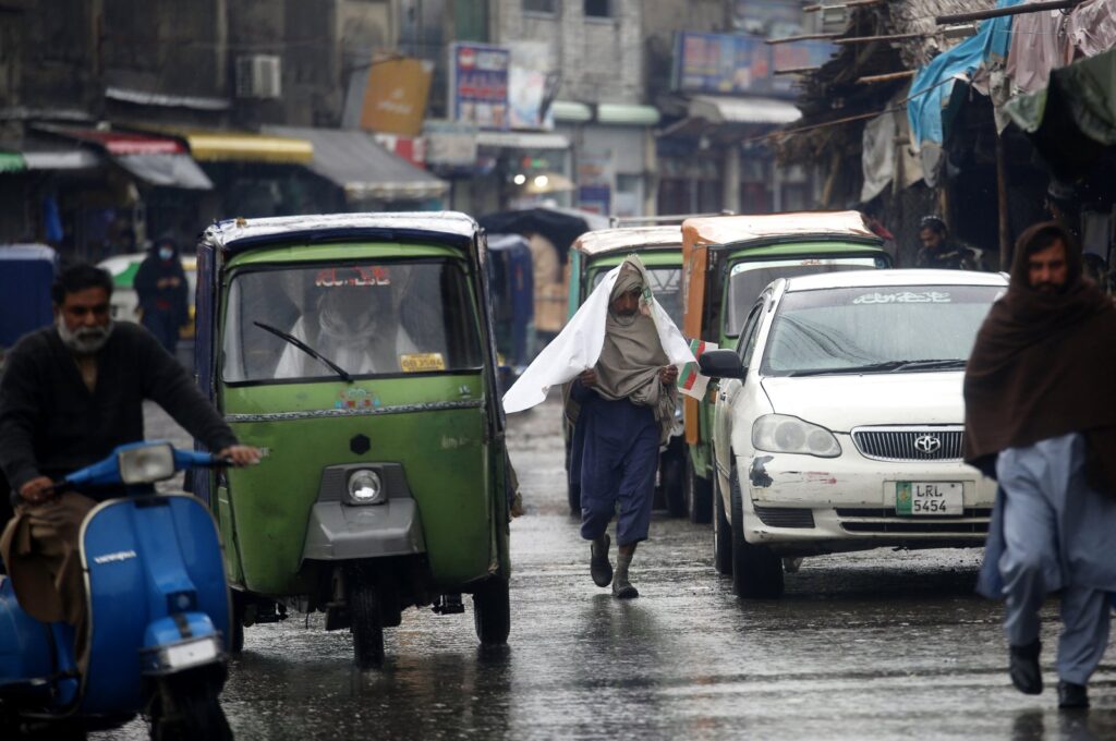People go on about their lives under heavy downpour in Peshawar, Pakistan, March 2, 2024. (EPA Photo)