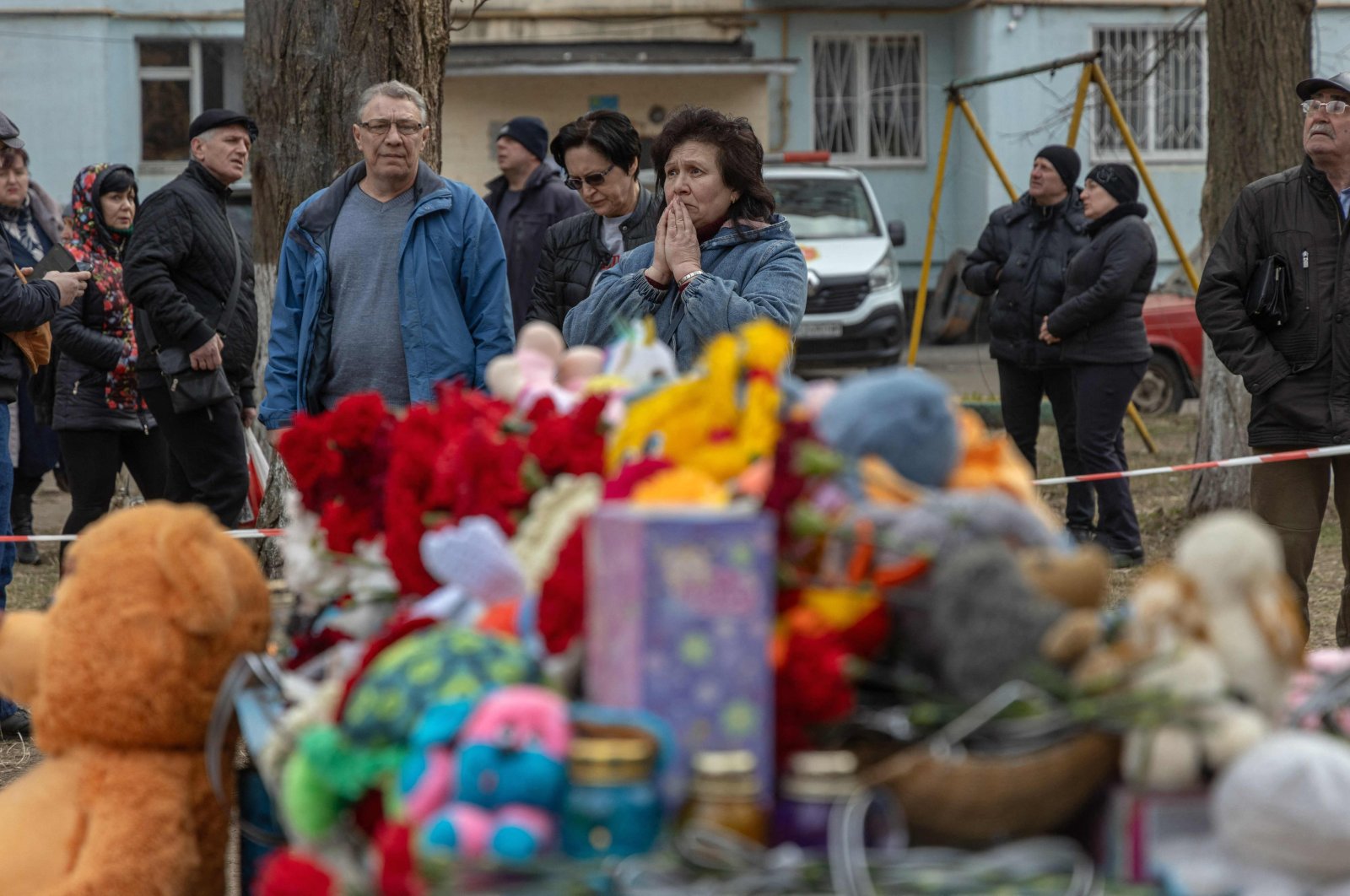 People react in front of toys displayed outside a multi-story building heavily damaged in Odesa, Ukraine, March 3, 2024. (AFP Photo)