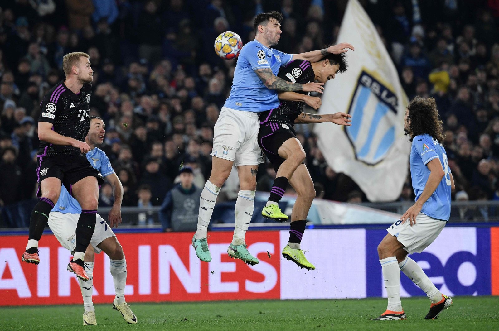 Lazio's Alessio Romagnoli (C) and Bayern Munich's Kim Min-Jae jump for the ball during the UEFA Champions League last 16 first leg, Olympic stadium, Rome, Italy, Feb. 14, 2024. (AFP Photo)