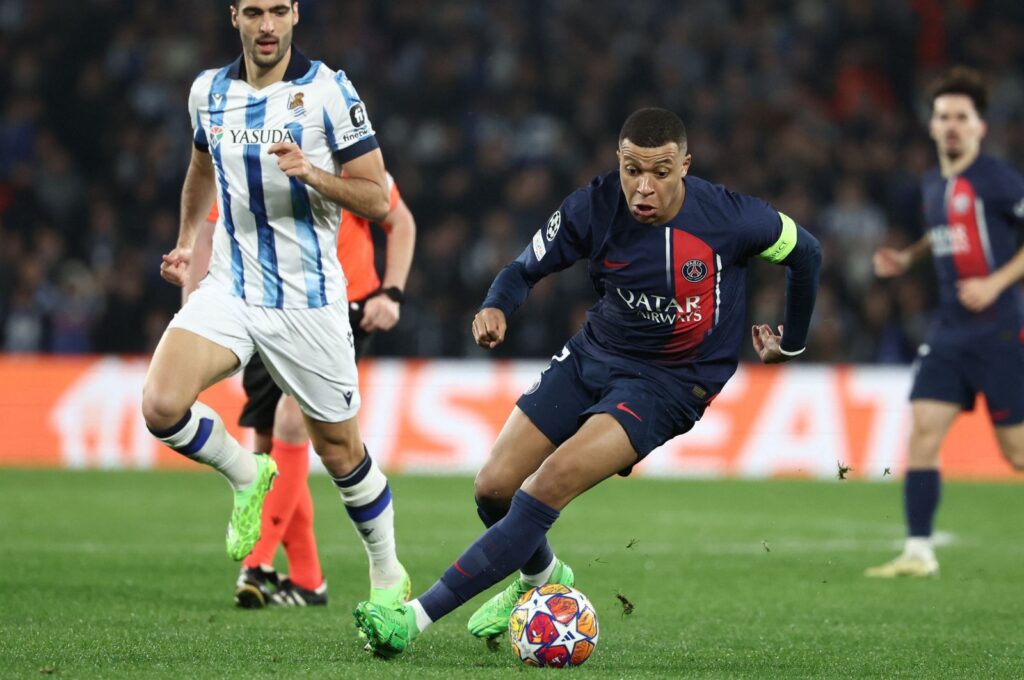 Paris Saint-Germain's Kylian Mbappe (R) is challenged by Real Sociedad's Mikel Merino during the UEFA Champions League last 16 second leg match at the Anoeta stadium, San Sebastian, Spain, March 5, 2024. (AFP Photo)