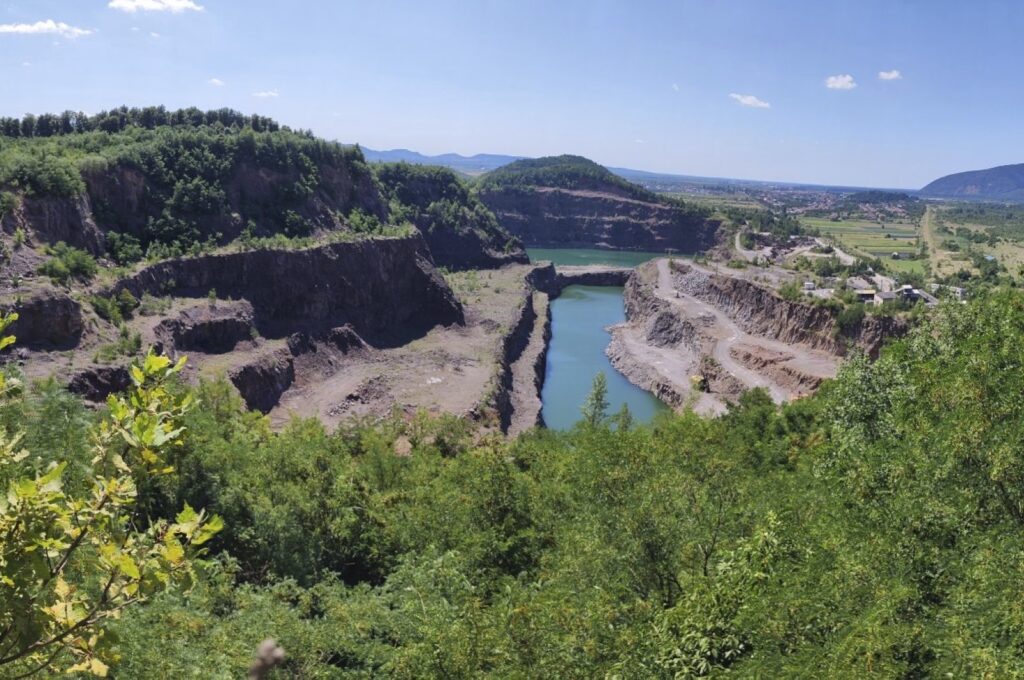 Gostry Verkh area of the Korolevo I archaeological site in western Ukraine in August 2023, with the Korolevo II site behind a body of water. (AP Photo)