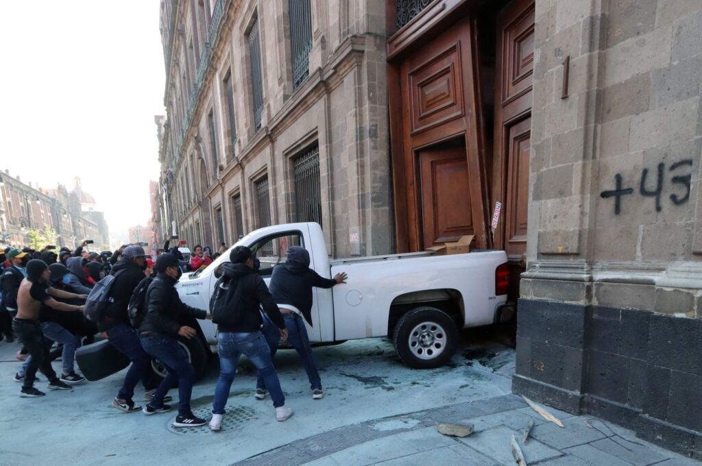 Demonstrators push a pickup truck to break down a presidential palace door in Mexico City, Mexico, March 6, 2024. (AFP Photo)