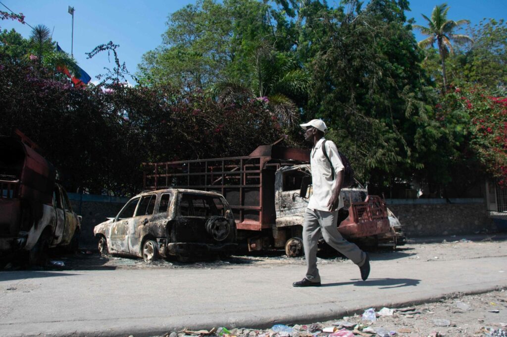 A man walks past carcasses of burnt-out vehicles in front of the police station at Carrefour de l’Aeroport, in Port-au-Prince, Haiti, March 5, 2024. (AFP Photo)