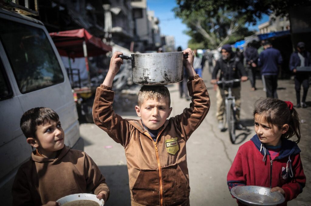 Palestinian children carry kitchen utensils as they walk toward a food distribution point in Khan Yunis, Gaza Strip, Palestine, March 7, 2024. (AFP Photo)