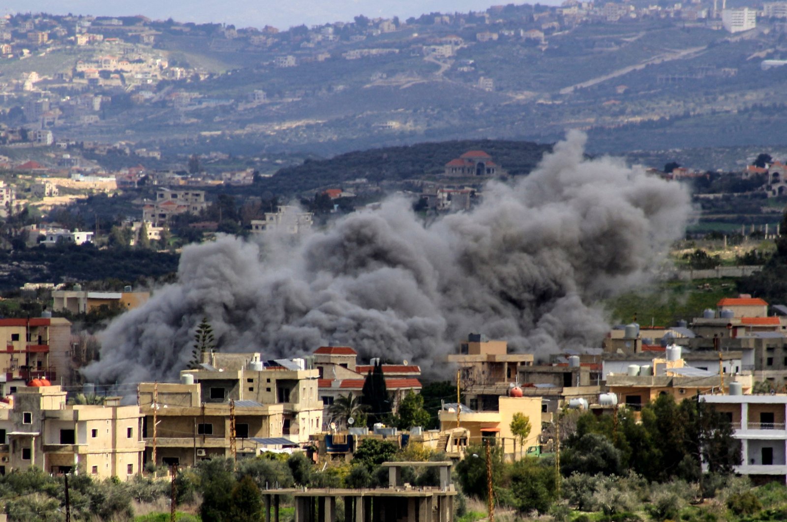 Smoke billows above buildings following an Israeli strike in the southern Lebanese border village of Majdal Zoun, March 9, 2024. (AFP Photo)