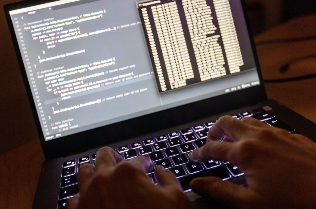 The source code of a web server and the Windows prompt can be seen on a laptop in the dark, Feb. 11, 2024. (Reuters File Photo)