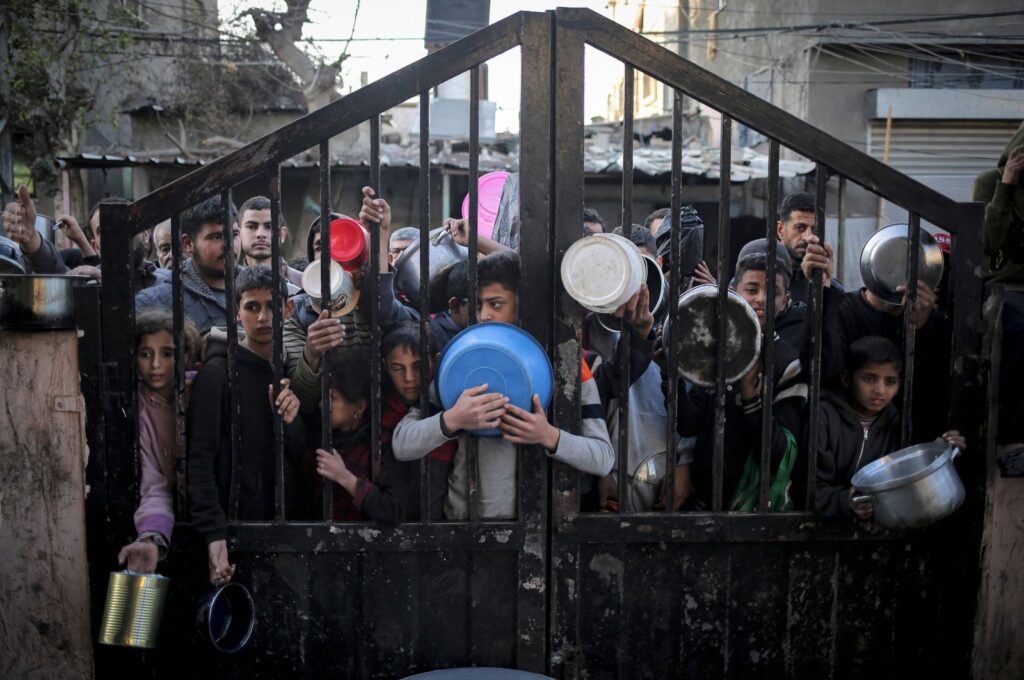 Displaced Palestinians gather to collect food aid before iftar, the breaking of the fast, on the first day of Ramadan, in Rafah, southern Gaza Strip, March 11, 2024. (AFP Photo)