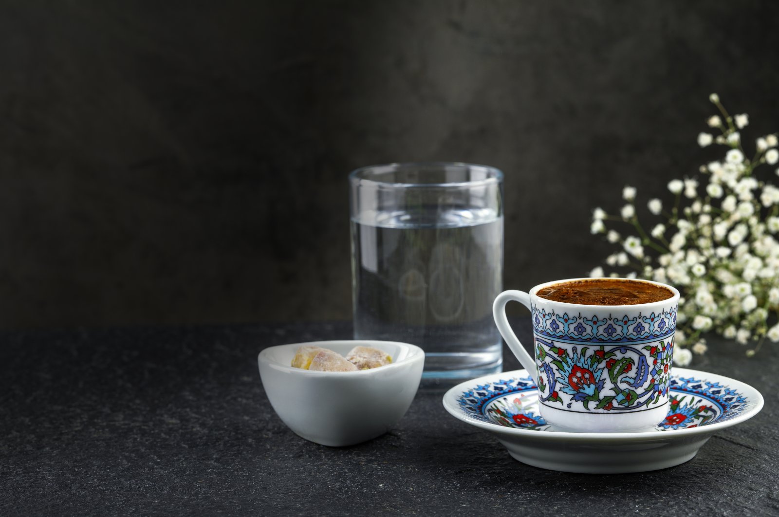 A traditional cup of Turkish coffee with foam, water glass and Turkish delights. (Shutterstock Photo)