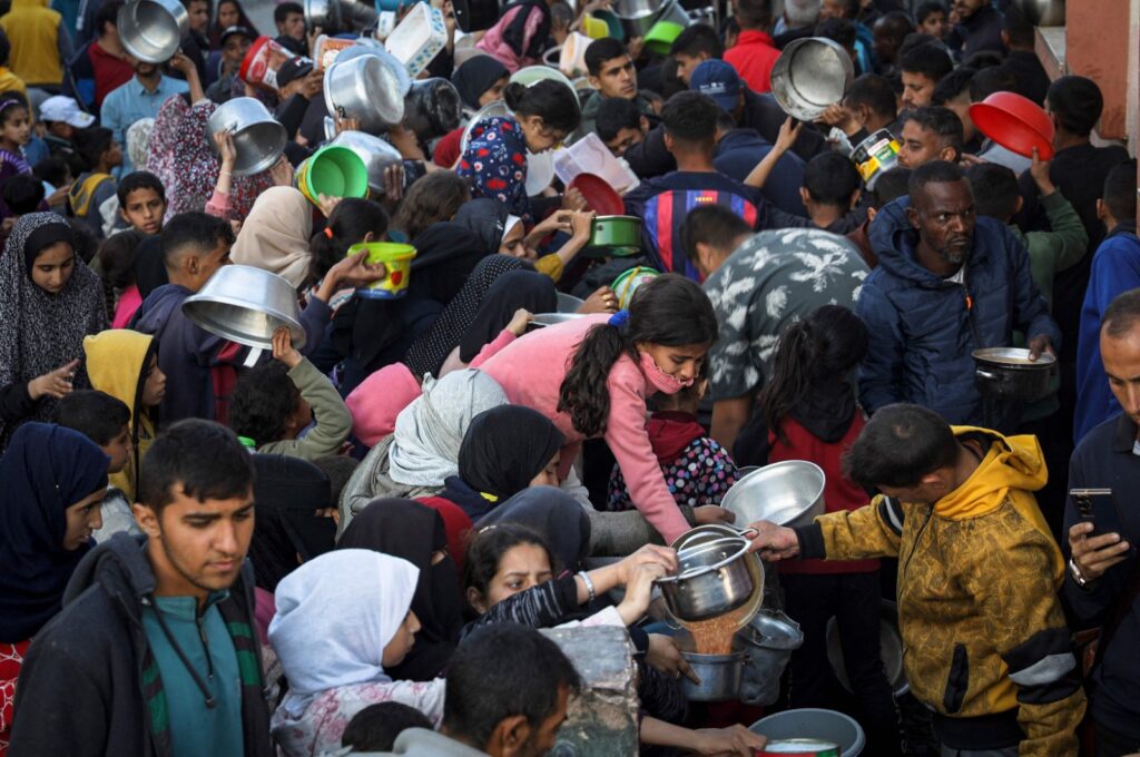 Displaced Palestinians collect food donated by a charity before an iftar meal, the breaking of the fast, on the first day of the Muslim holy fasting month of Ramadan, Rafah, Gaza Strip, Palestine, March 11, 2024. (AFP Photo)