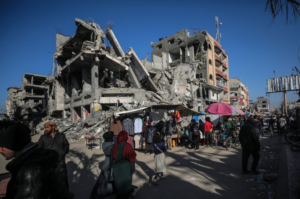 Palestinians walk past kiosks set up next to buildings destroyed by Israel along a street, on the first day of Ramadan, in Al-Nusairat refugee camp, Gaza Strip, Palestine, March 11, 2024. (EPA Photo)