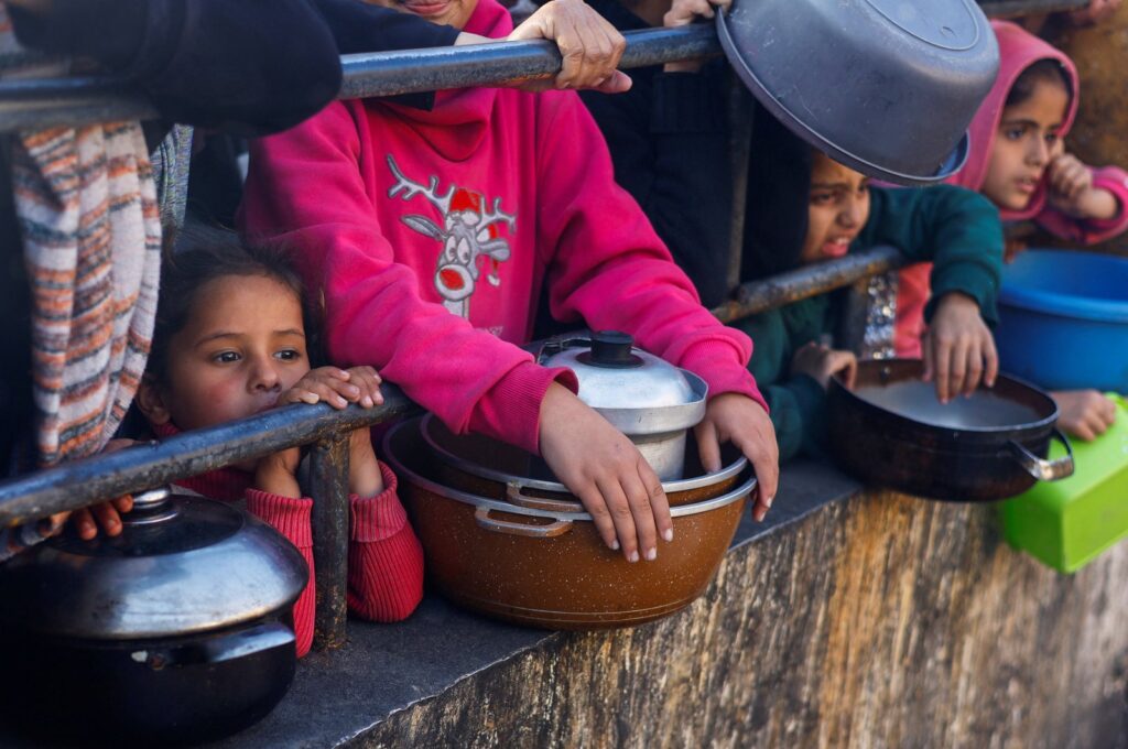 Palestinians wait to receive food during the Muslim holy fasting month of Ramadan, as the conflict between Israel and Hamas continues, in Rafah, in the southern Gaza Strip March 13, 2024. (Reuters Photo)