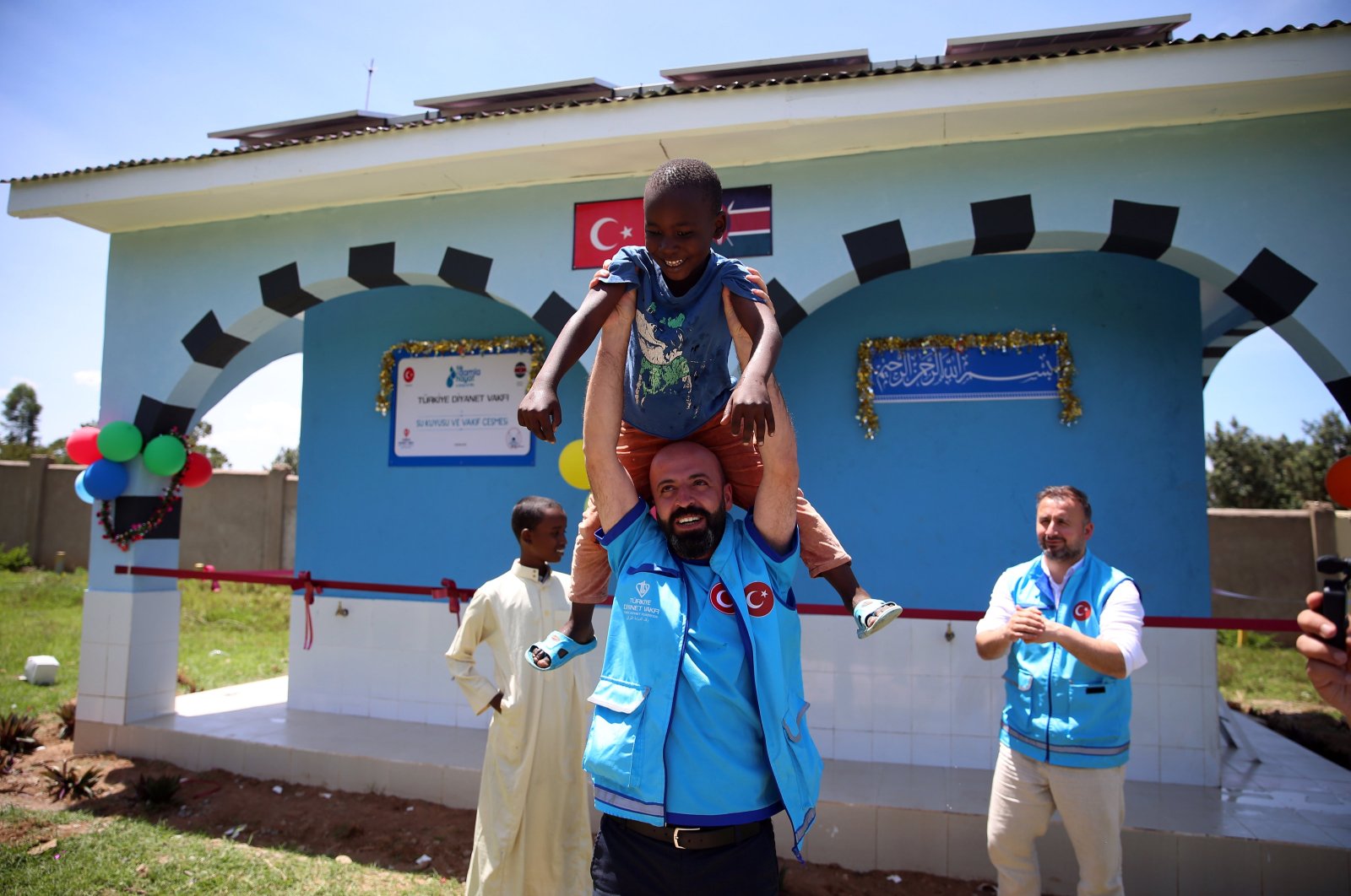 A staff member of the Presidency of Religious Affairs (Diyanet) cheers with a local boy during the opening ceremony of a water well, Bungoma, Kenya, March 13, 2024. (AA Photo)