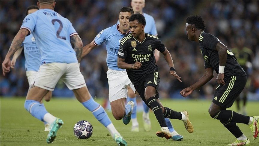 Real Madrid's Rodrigo (C) drives the ball between Manchester City's Kyle Walker and Rodri during the UEFA Champions League semifinal match at Etihad Stadium, Manchester, U.K., May 17, 2023. (AA Photo)