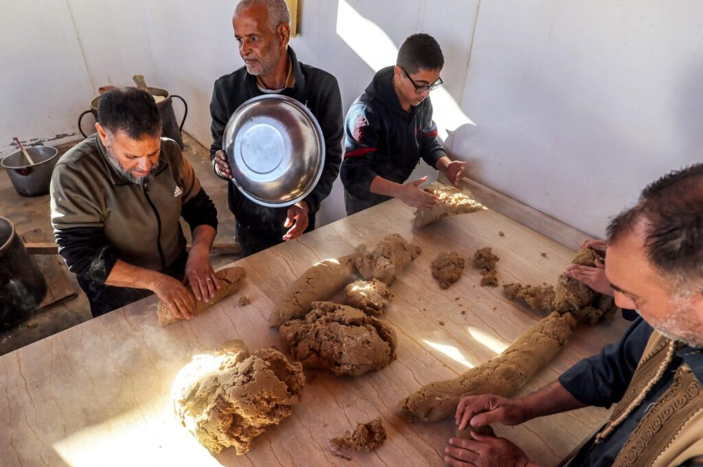 Volunteers cook portions of the traditional Libyan dish "bazin" in Tajura, Libya. March, 13, 2024. (AFP Photo)